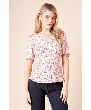 Charming polka dot pattern for a playful yet sophisticated look
        Flattering V-neckline with delicate frill detail
        Button-up front for easy wear and adjustable coverage
        Short puff sleeves add a touch of feminine charm
        Tie-back detail for a customisable fit and stylish accent
    
    This delightful top from Dorothy Perkins is the perfect addition to your wardrobe for those who love to embrace trends with a touch of modesty. The charming polka dot pattern creates a playful yet sophisticated look, ideal for various casual occasions. Style it with your favourite pair of dark wash jeans and comfortable trainers for a relaxed brunch with friends. For family gatherings or baby showers, pair it with tailored trousers and ballet flats for a polished ensemble. The tie-back detail allows for a customised fit, ensuring you feel comfortable and confident throughout the day. This versatile piece transitions seamlessly from daytime outings to early evening drinks, making it a must-have for the fashion-conscious woman who values both style and practicality in her wardrobe choices.
