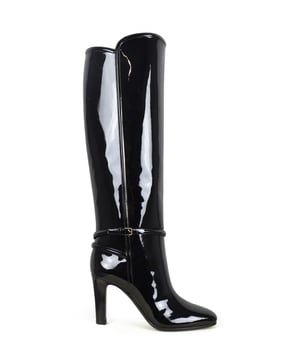 Bota Saint Laurent modelo Jane 90 en charol negro.Correa enrollada alrededor del tobillo con hebilla de metal.Tacón grueso estriado con una altura de 9 cm.Lengua extendida.Dedo del pie puntiagudo.Piel de becerro.Made in Italy.
