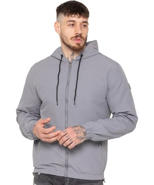 The Enzo Milano Men's Windbreaker Jacket offers a sleek, lightweight design with a regular fit. Made from durable tech fabric, it features a full zip, adjustable drawstring hood, and elasticated cuffs for added comfort and protection. With two concealed zip pockets, a single inner pocket, and an elasticated hem with a drawcord toggle, this water-Repellent jacket is perfect for everyday wear in light rain or windy conditions. Finished with the signature Enzo Milano rubber badge for a stylish touch.