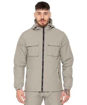 The Enzo Milano Men’s Lightweight Cargo Jacket is a sleek, functional outer layer made from water-repellent crushed poly fabric with a breathable mesh lining for all-day comfort. Designed in a regular fit, it features a full zip front, high neck, and adjustable drawcord hood for versatile coverage. With two Velcro chest pockets, two zippered side pockets, elasticated cuffs, and an adjustable drawcord hem, it offers both style and practicality—perfect for layering in changing weather.