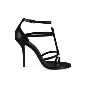 Sandalias Saint Laurent Cassandra mate negro. Tirantes finos adornados con una correa de tobillo con hebilla. Iniciales YSL en metal negro. Altura tacón 10 cm. Piel de becerro.Made in Italy.