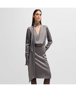 Dames BOSS Bascarva jurk met lange mouwen en sjaalhals in lichtgrijs. Een moderne jurk gemaakt door BOSS. Deze opvallende jurk heeft lange mouwen met manchetten met knopen en is gemaakt van glanzende stof voor een luxe uitstraling.  Dit langvallende ontwerp is afgewerkt met een vloeiende sjaal bij de halslijn.- Regular fit- Lange mouwen- Knoopmanchetten- Achtersplit- Paslengte achter: 105cm (41 inch)- Hoofdmateriaal: 72% acetaat 28% viscose.  Chemisch reinigen.- Ref: 50536538-089