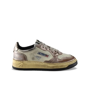 Super vintage zapatillas bajas Autry. En cuero laminado de color rosa viejo y cuero blanco. Efecto desgastado. Parche con logo en el lado exterior. Contrafuerte de cuero blanco con logotipo en relieve. Lengüeta con parche del logo. Suela de goma amarillenta de efecto vintage. Cierre de cordones planos beige. Punta redonda perforada. 100% cuero.