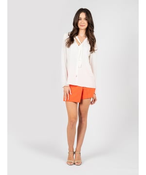 El diseño simple de esta elegante blusa hace que sea una elección perfecta para cualquier ocasión, añadiendo un toque de elegancia sutil y clase a cualquier atuendo.

Atada al cuello, esta blusa ofrece la posibilidad de ajustar el estilo a las preferencias personales, agregando a la vez un toque de sofisticación gracias a un nudo refinado.

El lazo adornado con un detalle de la marca no es solo un elemento práctico, sino también un sutil acento que destaca el prestigio y la atención al detalle de la marca.

Hecha de un tejido de alta calidad con un añadido de seda, la blusa no solo proporciona una apariencia lujosa, sino también un confort excepcional al llevarla, siendo agradable al tacto y delicada con la piel.

Producida en Italia, esta blusa combina la artesanía tradicional con un diseño moderno, lo que la convierte en una excelente elección para aquellos que valoran la calidad y el estilo.