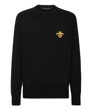 Este sofisticado jersey de cuello redondo combina a la perfección la comodidad con una elegancia discreta, lo que lo convierte en un básico versátil tanto para looks informales como elevados. Su confección de primera calidad garantiza un atractivo atemporal.   Confeccionado en algodón de alta calidad para un tacto suave y transpirable.   Presenta un sutil pero refinado escudo bordado que le da un toque de lujo.   Puños y dobladillo acanalados para un acabado elegante y a medida.    Ideal para llevar encima de camisas o solo para un estilo versátil.   Perfecta para combinar con pantalones de sastrería o vaqueros elegantes.