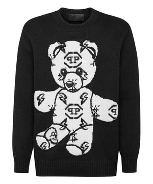 Jersey de lana merina con cuello redondo y tejido jacquard Teddy. En el canesú se ha cosido un lazo metálico con el logotipo. Dobladillo de punto elástico.