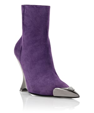 Muestra tu determinación y tu estilo a la moda con estas botas de ante hasta el tobillo. Revisa los detalles.   Parte superior de ante de color   Punta metálica con joya de calavera   Cuña de ABS forrada con metal   Lengüeta con logo en el cierre de cremallera lateral   Suela de cuero genuino pintada de leopardo   Forro interior   Tacón de 10.5 cm
