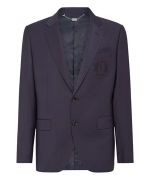 Este blazer atemporal ofrece una armoniosa mezcla de sofisticación y versatilidad, lo que lo convierte en una prenda imprescindible para un atuendo formal refinado o conjuntos informales elevados. Sus materiales de primera calidad y su elegante diseño garantizan un estilo duradero.   Confeccionada por expertos en lana de alta calidad para mayor comodidad y durabilidad.   Presenta un cierre de dos botones y solapas de muesca clásicas para una silueta entallada.   El discreto escudo bordado añade un detalle refinado y lujoso.   Incluye bolsillos funcionales con solapa y ribete para ofrecer estilo y practicidad.   Ideal para combinar con pantalones de sastrería, chinos o vaqueros elegantes.