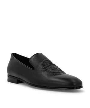 Estos mocasines de piel de becerro están adornados con la versión en silicona del emblemático escudo de la marca en la pala. Dobladillo ribeteado de napa. Forro de piel y plantilla extraíble. Suela de cuero auténtico.