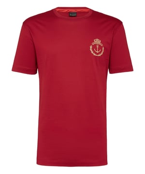 Esta camiseta de jersey de algodón presenta un emblema bordado de inspiración marinera en la parte izquierda del pecho. Presenta un emblema de metal más pequeño bordado en la tira para colgar en el canesú. Dos aberturas en la parte posterior. Cuello de canalé. Doble pespunte en ambos puños y el borde inferior.