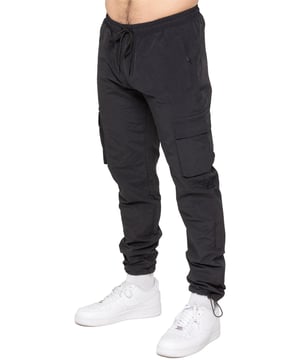 Stay ready for anything with the Enzo Milano Men’s Cargo Pants. Made from lightweight, poly fabric, these straight-leg trousers feature a regular fit, elasticated waistband with adjustable drawstring, and drawstring hems for a custom fit. With two Velcro-fastened side cargo pockets and a back welt pocket, they offer secure, practical storage. Perfect for everyday wear, travel, or outdoor use, these men’s cargo pants combine comfort, function, and style.