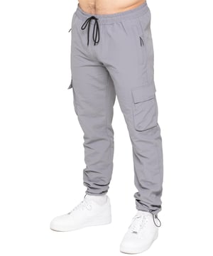 Stay ready for anything with the Enzo Milano Men’s Cargo Pants. Made from lightweight, poly fabric, these straight-leg trousers feature a regular fit, elasticated waistband with adjustable drawstring, and drawstring hems for a custom fit. With two Velcro-fastened side cargo pockets and a back welt pocket, they offer secure, practical storage. Perfect for everyday wear, travel, or outdoor use, these men’s cargo pants combine comfort, function, and style.