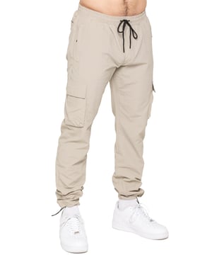 Stay ready for anything with the Enzo Milano Men’s Cargo Pants. Made from lightweight, poly fabric, these straight-leg trousers feature a regular fit, elasticated waistband with adjustable drawstring, and drawstring hems for a custom fit. With two Velcro-fastened side cargo pockets and a back welt pocket, they offer secure, practical storage. Perfect for everyday wear, travel, or outdoor use, these men’s cargo pants combine comfort, function, and style.