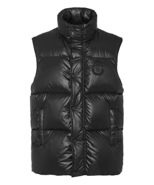 Este elegante chaleco de nailon combina la sofisticación urbana con una calidez excepcional, lo que lo convierte en un básico versátil para las temporadas de transición o para vestir a capas en climas más fríos.    Exterior de nailon de primera calidad para una mayor durabilidad y una estética elegante.   Lujoso relleno de 90% de plumón de ganso y 10% de plumas de ganso para un aislamiento superior.   Diseño de cuello alto con cierres a presión para sellar el calor.   Detalle de escudo bordado que añade un toque de refinamiento.   Bolsillos laterales funcionales para mayor practicidad y comodidad.