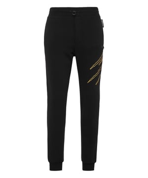 Estos pantalones de jogging diseñados para cualquier entrenamiento, son el complemento perfecto para alcanzar tus objetivos. Comodidad y rendimiento se suman al estilo de Plein Sport.   Forro polar de algodón   Patrón estampado en la parte delantera y trasera   Cintura de punto elástico con cordón   Parche cosido en la pernera izquierda   Dos bolsillos con aberturas   Puños inferiores de punto elástico.