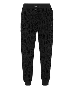 Descubra la originalidad de estos pantalones de jogging jacquard.   Tejido de mezcla de algodón con estampado flocado por toda la prenda.   Parche con logotipo   Bolsillos con aberturas   Cintura de canalé con cordón de ajuste de tope   Puños de punto elástico