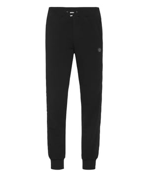 Descubra la originalidad de estos pantalones de chándal de forro polar de mezcla de algodón decorados con costuras únicas.   Vellón de mezcla de algodón   Detalles de nailon acolchado   Hexágono de PP en una insignia de cuero saffiano cosida en la pernera izquierda   Bolsillos con aberturas   Cintura de punto elástico con cordón de tope   Puños de punto elástico