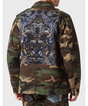 Descubra el nuevo tema de la temporada en esta chaqueta safari de gabardina con inserciones de tejido estampado que crean un efecto patchwork. Eche un vistazo a sus detalles distintivos.   Gabardina de algodón con estampado de camuflaje   Parches de tejido con estampado Paisley estilo bandana cosidos aleatoriamente en la prenda   Hexágono PP en un parche de cuero saffiano cosido en el pecho izquierdo   Botones a presión   Dos bolsillos de parche con solapa   Forro de tejido acolchado a rombos