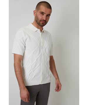 Combine classic style with modern comfort with this knitted polo shirt from Threadbare. With a ribbed placket with button-through fastening, this shirt has a Milano stitch collar and ribbed cuffs and hem. In an all-over textured knit, made from a cotton blend yarn and finished with a metal Threadbare tab above the hem. Pair with chinos or jeans for everyday wear or team with shorts for summer style.