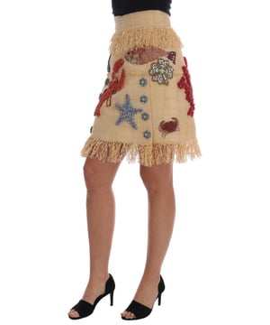 Marca: Dolce & Gabbana  
Modelo: Falda de cintura alta por encima de la rodilla  
Color: Beige  
Bordado: Inspirado en el mar, bordado a mano con cristales de colores  
Cierre con cremallera y gancho  
Forro interior de seda beige  
Detalles del logo  
Hecho en Italia  
Material: 100% Fibra de Palma