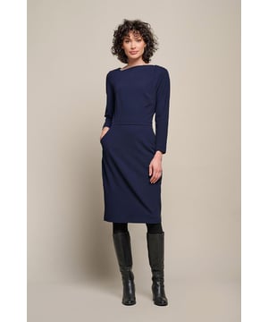 De Novelle Jurk in navy is vervaardigd uit een comfortabele, elastische stof genaamd screpino. Deze jurk heeft een gedrapeerde, asymmetrische halslijn en een tailleband die je figuur mooi accentueert. De donkerblauwe jurk heeft een getailleerde pasvorm, lange mouwen en valt net boven de knie. De samenstelling van 95% polyester en 5% elastaan zorgt voor een perfecte pasvorm, comfortabele stretch en uitstekende duurzaamheid. Het polyester maakt de jurk bovendien makkelijk te onderhouden.Met zijn gedrapeerde halslijn en strakke pasvorm is de Novelle Jurk een elegante en vrouwelijke keuze. De tailleband benadrukt je figuur en creëert een flatterend silhouet. De lengte boven de knie zorgt voor een moderne, speelse uitstraling. Deze jurk is geschikt voor verschillende gelegenheden, van een formele gebeurtenis tot een avondje uit. Combineer de jurk met hakken en accessoires voor een chique look, of draag hem met ballerina's en een denim jasje voor een meer casual en ontspannen stijl. Door de comfortabele pasvorm, het trendy ontwerp en de opvallende kleur is de Novelle Jurk een veelzijdig kledingstuk dat je zelfvertrouwen en stijl naar een hoger niveau tilt.