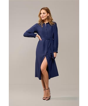 Deze navy doorknoopjurk uit de nieuwste Mart Visser collectie is een echte must-have. Het tijdloze ontwerp is perfect voor elke dag, met een stijlvolle uitstraling die nooit uit de mode raakt. De lange jurk is gemaakt van een soepele travelstof en wordt geleverd met een bijpassende strikceintuur, zodat je de perfecte pasvorm kunt creëren. De jurk heeft handige steekzakken, een klassieke kraag en elastische details bij de mouwen, die een subtiel ruche-effect geven. De donkerblauwe jurk heeft een recht vallende pasvorm en komt tot net boven de kuit. Daarnaast kun je de jurk ook open dragen als een lange blouse, bijvoorbeeld gecombineerd met een lichte jeans en een stijlvolle top of een basic singlet. Kijk ook naar de zwarte versie van deze jurk of de Trenton-jack, gemaakt van dezelfde comfortabele stof. Deze prachtige navy jurk is een perfecte aanvulling op je garderobe dit seizoen en zal zeker een statement maken!