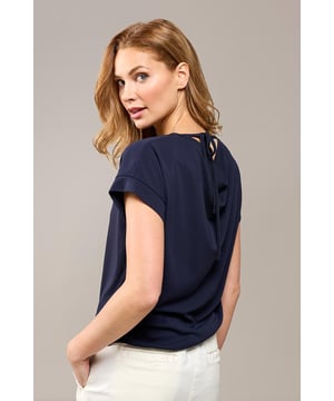 De Raisy Top Navy combineert moeiteloos moderne elegantie met verfijnde eenvoud. Deze donkerblauwe jersey top straalt klasse uit dankzij de subtiele, vrouwelijke mouwdetails en de opvallende halslijn aan de achterkant, die een speels en uniek accent toevoegt. De rechtlijnige, los vallende pasvorm maakt de top flatterend en comfortabel voor elk lichaamstype. De heuplengte draagt bij aan de veelzijdigheid van de Raisy Top, waardoor deze geschikt is voor uiteenlopende gelegenheden. Gemaakt van een lichte, soepele polyester stof, biedt de top een aangenaam draagcomfort, ideaal voor warme dagen en stijlvolle avonduitjes.