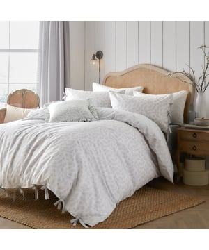 Transform your bedroom into a serene haven with the Chloe Duvet Cover Set, thoughtfully designed for those who cherish delicate patterns. Made from 100% tumbled cotton with a luxurious 144 thread count, it offers unmatched softness and comfort. The reversible design, featuring a serene tonal leaf print on both sides, allows for effortless style refreshes, perfectly blending elegance and versatility. Charming bow closures on the duvet and pillowcases add a touch of character, combining country charm with modern aesthetic. Crafted with care, this set brings a harmonious balance of sophistication and cosiness to your space.