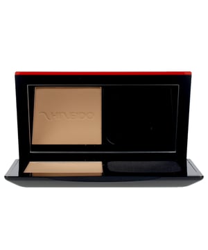 SYNCHRO SKIN ANPASSBARES Puder von Shiseido, Farbton #360. Diese cremige Puderfundation kann sowohl trocken als auch feucht aufgetragen werden und sorgt für ein natürliches, perfektes Finish, das nicht von Schweiß, natürlichen Hautölen oder Gesichtsausdrücken beeinflusst wird. Mit der innovativen ActiveForceTM-Technologie passt sich diese Make-up-Basis ideal an die Haut an und gewährleistet ein makelloses Aussehen für 24 Stunden, ohne dass eine Nachbesserung notwendig ist. Dank ihrer sensorischen Technologie reagiert sie auf den Zustand, den Farbton und die Beschaffenheit der Haut, wodurch diese ein strahlendes Aussehen erhält. Ein herausragender Inhaltsstoff ist der Extrakt des wilden Thymians, der antioxidative Eigenschaften bietet. Zusätzlich besitzt die Formel antihaftende Eigenschaften, die einen Schutzschild bilden, um zu verhindern, dass Verunreinigungen und äußere Einflüsse die Haut belasten oder schädigen.