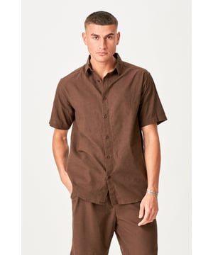 Esta camisa de lino de manga corta en marrón oscuro es la elección perfecta para el hombre con estilo. Con su material ligero y transpirable, compuesto por 70% algodón y 30% lino, garantiza el máximo confort incluso en los días más calurosos. Ideal tanto para ocasiones formales como informales, esta camisa combina elegancia con funcionalidad. El tono café atemporal complementa cualquier guardarropa, haciéndolo indispensable para el hombre moderno. Da un paso hacia las tendencias del verano con esta camisa versátil, creada para impresionar y ofrecer un estilo elegante.