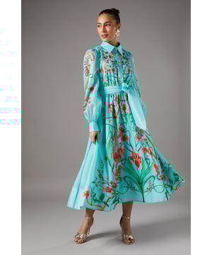 Striking boarder print organza shirt dress
        Elegant collared neckline with button-down front
        Voluminous long sleeves with cuffed wrists
        Cinched waist with a matching fabric belt
        Midi length with a graceful A-line silhouette
    
    Make a captivating entrance at your next special occasion with this exquisite boarder print organza shirt dress from Coast. The eye-catching floral pattern adorns the lightweight, semi-sheer fabric, creating a romantic and ethereal look. Perfect for weddings, garden parties, or race day events, this dress combines sophistication with a touch of whimsy. Style it with strappy metallic sandals and statement earrings, as seen on our model, for a polished ensemble. For cooler evenings, drape a pashmina over your shoulders or opt for a cropped jacket to maintain the dress's beautiful silhouette. The versatile design allows for both daytime elegance and evening glamour, ensuring you'll stand out at any event with effortless grace and charm.