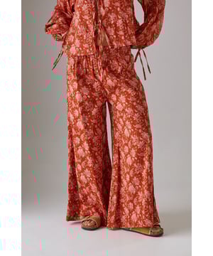 Lightweight cheesecloth fabric with all-over print creates a breezy, effortless silhouette
        Shirred waistband offers comfortable stretch whilst defining the waist
        Dramatic wide leg cut provides maximum movement and a fashion-forward profile
        Floor-skimming length creates an elongated, elegant line
        Coordinating top available for a striking head-to-toe ensemble
    
    These statement wide leg trousers combine comfort with contemporary style for your everyday wardrobe. The shirred waistband creates a flattering fit that sits perfectly at your natural waist, whilst the flowing wide leg cut delivers a relaxed yet sophisticated silhouette. Style with the matching top as seen on our model for a coordinated daytime look, or pair with a simple fitted tee and trainers for casual weekend brunches. The lightweight cheesecloth fabric makes these trousers ideal for warmer days or layering during transitional seasons. Add a chunky knit and ankle boots when temperatures drop, or dress up with metallic sandals and a woven tote for garden parties or al fresco dining. These versatile trousers will quickly become your go-to for effortless daywear styling.