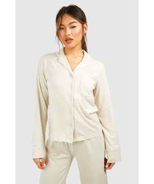 Collared button-front design for a classic look
        Soft jersey fabric for ultimate comfort
        Long sleeves with cuffed details
        Relaxed fit for effortless lounging
        Versatile piece that can be styled for various occasions
    
    Embrace laid-back luxury with this Button Front Lounge Shirt from Boohoo. Perfect for those cosy nights in or lazy weekend mornings, this versatile piece combines style and comfort effortlessly. The classic collared design adds a touch of sophistication to your loungewear collection, while the soft jersey fabric ensures you stay comfortable all day long. Pair it with the matching trousers for a coordinated look, or throw it over your favourite leggings for a more casual vibe. Whether you're binge-watching your latest TV obsession or hosting an intimate brunch with friends, this lounge shirt is your go-to for looking put-together without sacrificing comfort. Its adaptable nature means you can easily dress it up with some statement jewellery for those impromptu video calls or keep it simple for a relaxed day at home. With Boohoo's Button Front Lounge Shirt, you'll redefine your at-home style game.