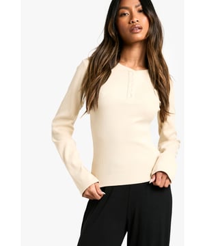 Ribbed texture for added comfort and style
        Long sleeves for cosy warmth
        Henley neckline with button detail
        Fitted silhouette for a flattering look
        Versatile design suitable for various loungewear outfits
    
    Embrace laid-back luxury with this ribbed loungewear top from Boohoo. Perfect for those lazy days at home or casual weekends, this piece combines comfort with style effortlessly. The fitted silhouette accentuates your figure while allowing for easy movement. Pair it with wide-leg trousers as shown for a chic, relaxed ensemble. The henley neckline adds a touch of interest, making it ideal for video calls or impromptu doorstep chats. Layer it under a cosy cardigan for extra warmth during chilly evenings, or wear it solo for a streamlined look while you unwind with your favourite book or binge-watch series. This versatile top is a must-have addition to your loungewear collection, offering both comfort and style for your at-home moments.