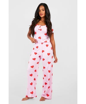 Charming heart print pyjama set
        Button-front top with short sleeves
        Scoop neckline for a feminine touch
        Comfortable wide-leg trousers
        Soft jersey fabric for ultimate comfort
    
    Indulge in sweet dreams with this adorable heart print pyjama set from Boohoo. Perfect for the fashion-forward sleeper, this ensemble combines style and comfort effortlessly. The button-front top features a flattering scoop neckline and short sleeves, ideal for those warm nights. Paired with wide-leg trousers, this set offers unrestricted movement for a restful slumber. The soft jersey fabric ensures a cosy feel against your skin, making it perfect for lounging on lazy weekends or having a girls' night in. Whether you're settling down for a Netflix marathon or enjoying your morning coffee, these pyjamas will keep you feeling chic and comfortable. Embrace your playful side and add a touch of romance to your nightwear collection with this charming set that's sure to become a bedtime favourite.