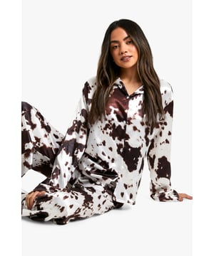 Eye-catching cow print design for a playful nightwear look
        Long-sleeved top with classic collar for added comfort
        Satin fabric offers a luxurious feel against the skin
        Matching trousers with relaxed fit for unrestricted movement
        Versatile two-piece set perfect for lounging or sleeping
    
    Embrace a touch of whimsy in your nightwear collection with this charming long-sleeved pyjama set. The striking cow print pattern adds a dash of fun to your bedtime routine, while the satin fabric ensures a smooth and comfortable feel throughout the night. The classic collared top paired with relaxed-fit trousers offers both style and practicality. Whether you're settling in for a cosy night's sleep or enjoying a lazy weekend morning, this set is the perfect companion. For those chilly evenings, layer with a soft dressing gown and fluffy slippers to complete your loungewear look. This Boohoo pyjama set is not just for bedtime - it's versatile enough for casual at-home entertaining or virtual catch-ups with friends, allowing you to look put-together even in your most comfortable attire.
