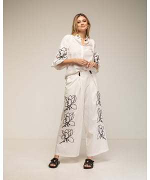 Set van broek en blouse met geborduurde bloemen op de mouwen, kraag en broek. Gepofte mouwen en broek met figuurnaden en zakken.