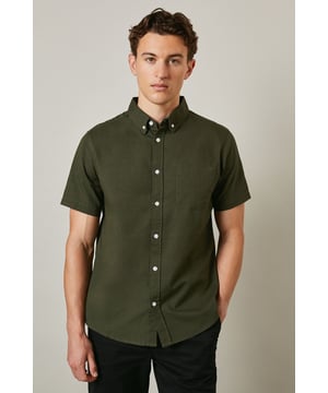 Textured woven cotton fabric with subtle surface detail for added visual interest
        Classic button-down collar with short sleeves for warm-weather comfort
        Clean-cut design featuring a single back pleat for improved movement
        Traditional front button fastening with contrasting white buttons
        Versatile regular fit that suits a variety of body types
    
    This Maine textured short sleeve shirt combines timeless style with everyday practicality. The breathable cotton construction ensures all-day comfort whilst the subtle texture adds character to this wardrobe essential. Perfect for casual weekend outings, pair it with dark shorts and white trainers as shown for an effortlessly cool summer look. The versatile design also works brilliantly with chinos or jeans for family gatherings or informal social events. Layer under a lightweight jacket when the temperature drops or wear it unbuttoned over a plain t-shirt for a more relaxed approach. The button-down collar maintains a smart appearance even without a tie, making this shirt an ideal choice for those occasions that sit between casual and smart-casual. Machine washable at 30 degrees, it's designed to maintain its shape and appearance with proper care.
