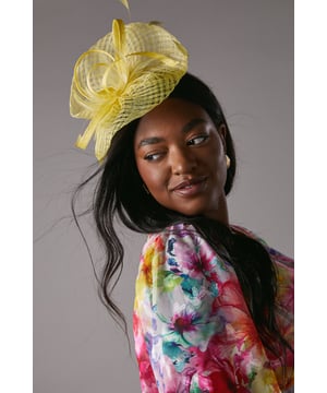 Offering a bold take on race-day style or adding a flair to wedding guest dressing, fascinators are our favourite accessory. Beautifully complementing our formal outfitting, this hat is an instant sartorial statement. Crafted out of signature sinamay, a natural straw fabric made from abaca fibres, this  piece uses an open weave to add texture and is sculpted into loops. Fixes with a headband and delivered in a box.