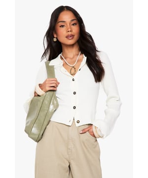 Stylish collared cardigan with distinctive button-through front design
        Cropped silhouette that sits perfectly at the waistline for a flattering fit
        Long sleeves with neat ribbed cuffs for added comfort and structure
        Versatile layering piece that works seamlessly with casual and smart-casual outfits
        Classic collar detail adds a sophisticated touch to this wardrobe essential
    
    This chic collared cardigan brings a refined twist to everyday knitwear. The cropped design creates a flattering silhouette that pairs beautifully with high-waisted trousers, as styled on our model. Perfect for transitional weather, layer it over a simple vest top for daytime casual, or button it up as a standalone piece for a more polished look. The distinctive collar detail adds character to this versatile piece, making it ideal for family gatherings or weekend brunches. For a contemporary casual ensemble, team with wide-leg trousers and trainers, adding statement jewellery to enhance the look. This cardigan effortlessly bridges the gap between comfort and style, making it an indispensable addition to your wardrobe that can be styled countless ways throughout the seasons.