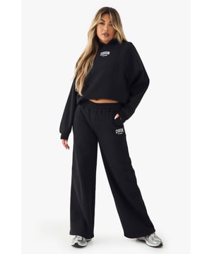 Straight leg joggers with distinctive Dsgn Studio embroidery detail
        Wide-leg silhouette for maximum comfort and contemporary styling
        Elasticated waistband for a secure yet comfortable fit
        Side pockets for practicality and everyday convenience
        Coordinating set available with matching cropped top for a complete look
    
    These straight leg joggers redefine casual comfort with their relaxed wide-leg silhouette and signature Dsgn Studio embroidery. Perfect for those laid-back days when style shouldn't compromise comfort, they pair brilliantly with the matching cropped top as shown for an effortlessly coordinated ensemble. Style with chunky trainers for daytime outings or dress up with a fitted bodysuit and statement jewellery for casual gatherings. The versatile straight-leg design flatters all body types while providing unrestricted movement. Ideal for weekend brunches, university lectures, or simply lounging at home, these joggers offer the perfect balance of fashion-forward design and everyday wearability. The contemporary wide-leg cut makes them a standout piece in your casual wardrobe rotation.