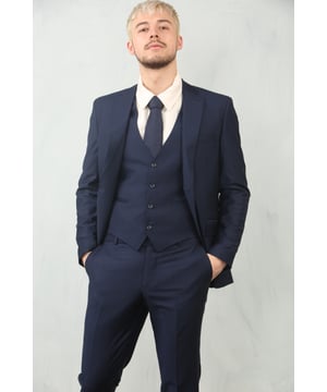 Adéntrate en la elegancia atemporal con este traje de 3 piezas en azul marino, diseñado para ofrecer tanto sofisticación como comodidad en cualquier ocasión formal. El clásico diseño liso en azul marino garantiza versatilidad en diversos eventos, desde bodas y bailes de graduación hasta reuniones de negocios y funciones nocturnas. La sastrería experta proporciona un ajuste estructurado y favorecedor, mientras que los sutiles detalles de puntada en las solapas añaden un toque refinado. Compuesto por una chaqueta, un chaleco y pantalones, este traje es tu opción ideal para un look pulido y seguro.\nAjuste a medida: Estructurado para una silueta moderna que combina estilo y comodidad.\nDiseño liso en azul marino: Elegante y versátil, perfecto para eventos formales y profesionales.\nConjunto completo de 3 piezas: Incluye chaqueta, chaleco y pantalones para un look coordinado.\nDetalles de puntada en las solapas: Aportan refinamiento sutil y carácter al diseño general.\nComposición del material: 65% poliéster, 32% viscosa, 3% licra.
