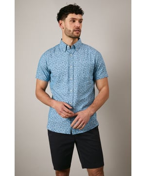 Button-down collar for a classic, structured look
        Delicate ditsy floral print creates a subtle pattern throughout
        Short sleeves with neat hems for warm-weather comfort
        Box pleat at the back for enhanced movement and fit
        Regular fit with curved hem suitable for both tucked and untucked styling
    
    This Maine short sleeve shirt brings a refreshing touch to your casual wardrobe with its charming ditsy floral print. The woven fabric offers a comfortable feel whilst maintaining a smart appearance, perfect for those relaxed yet put-together moments. Style with dark chino shorts and white trainers as shown for effortless summer outings, or pair with slim-fit denim and canvas shoes for weekend brunches. The versatile design works brilliantly for family gatherings, garden parties, or casual Friday office settings. For cooler evenings, layer under a lightweight bomber jacket or cardigan without compromising on style. The button-down collar adds structure to this otherwise laid-back piece, making it an essential addition to your warm-weather collection that transitions seamlessly from daytime casual to evening socialising.