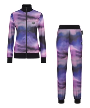 Echa un vistazo al nuevo chándal haciendo que tus sesiones deportivas y tus momentos de ocio destaquen.   Triacetato de mezcla de algodón con estampado óptico de desvanecimiento de color.   La Marca aparece en la parte trasera de la parte superior   Parche engomado con el emblema de la Marca cosido tanto en la chaqueta como en el pantalón   Cierre de cremallera impermeable en la chaqueta   Bolsillos con aberturas   Dobladillos de punto elástico