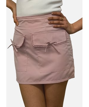 Esta minifalda de microfalda rosa cuenta con un elegante lazo y detalles de bolsillos que añaden un toque de elegancia informal a tu vestuario. Cómoda de llevar y versátil para cualquier ocasión, esta falda es imprescindible para quienes buscan estar a la última.