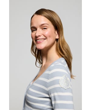 Die Damenstrickjacke Cordelia ist ein maritim inspiriertes Stück, das Eleganz und Funktionalität vereint. Sie ist aus Baumwolle und Polyamid gefertigt und hat eine schmale Passform mit V-Ausschnitt, die eine schlanke Silhouette schafft. Der Knopfverschluss mit farblich abgestimmten Logoknöpfen sorgt für ein raffiniertes Finish, während die Rippbündchen an den Ärmeln und am Bund für einen bequemen Sitz sorgen. Das farblich abgestimmte Nahtband am Kragen mit Polo Club Logo unterstreicht die Eleganz dieses Modells. Das kontrastierende Streifendesign und das einfarbige gestickte Wappen auf dem Ärmel sind ikonische Details unserer maritimen Kollektion.