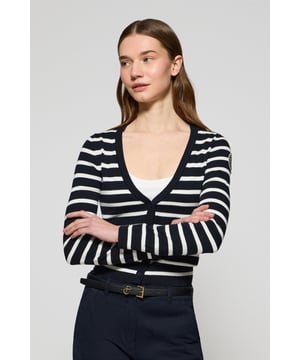 Die Damenstrickjacke Cordelia ist ein maritim inspiriertes Stück, das Eleganz und Funktionalität vereint. Sie ist aus Baumwolle und Polyamid gefertigt und hat eine schmale Passform mit V-Ausschnitt, die eine schlanke Silhouette schafft. Der Knopfverschluss mit farblich abgestimmten Logoknöpfen sorgt für ein raffiniertes Finish, während die Rippbündchen an den Ärmeln und am Bund für einen bequemen Sitz sorgen. Das farblich abgestimmte Nahtband am Kragen mit Polo Club Logo unterstreicht die Eleganz dieses Modells. Das kontrastierende Streifendesign und das einfarbige gestickte Wappen auf dem Ärmel sind ikonische Details unserer maritimen Kollektion.