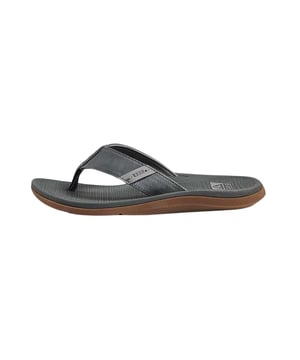 Entdecken Sie die perfekten Begleiter für den Sommer: die Reef Zehentrenner für Herren. Diese Sandalen vereinen Komfort und Stil in einem leichten Design, das für warme Tage am Strand oder in der Stadt gemacht ist. Mit ihrer flachen Absatzform und schmalen Schuhweite passen sie sich ideal an Ihre Füße an und bieten optimalen Halt.  Dank der wasserfreundlichen Materialien sind sie die perfekten Begleiter für alle Aktivitäten am und im Wasser. Sie sind leicht, aber dennoch stabil, und halten jedem Abenteuer stand. Die Reef Zehentrenner sind mehr als nur Schuhe; sie sind ein Gefühl von Freiheit und Unbeschwertheit.  Ob am Strand, Pool oder bei einem Spaziergang durch die Stadt, diese Slipper bieten Ihnen den Tragekomfort, den Sie an heißen Sommertagen brauchen. Sie sind nicht nur funktional, sondern auch ein stylisches Accessoire, das zu jedem Freizeitoutfit passt.  Genießen Sie die Kombination aus Qualität und lässigem Design, die Reef Ihnen bietet. Gönnen Sie Ihren Füßen den Komfort, den sie verdienen, und erleben Sie unvergessliche Sommermomente in diesen vielseitigen Zehentrennern.
