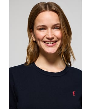 Dieser kurzärmlige Damenstrickpullover ist die perfekte Kombination aus Eleganz und Komfort. Er ist aus weicher Baumwolle gefertigt und hat eine reguläre Passform, die sich sanft an die Silhouette anschmiegt. Der Rundhalsausschnitt und die gerippten Abschlüsse an den Ärmeln, am Kragen und am Bund sorgen für einen bequemen Sitz. Das marineblaue Nahtband am Kragen mit Polo Club Logo unterstreicht die Eleganz dieses Modells. Das emblematische Rigby Go Logo in Kontrastfarbe auf der Brust unterstreicht seine einzigartige Optik. Ideal allein getragen der in Kombination mit unserer geknöpften Strickjacke.