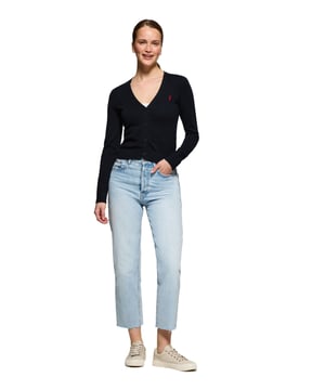 Diese schmal geschnittene Damenstrickjacke mit V-Ausschnitt ist aus Baumwolljersey gefertigt und bietet die perfekte Kombination aus Komfort und Stil. Rippbündchen an den Ärmeln und in der Taille sorgen für die perfekte Passform. Das dezente Nahtband an der Innenseite des Kragens mit Polo Club Logo unterstreicht die Eleganz dieses Kleidungsstücks. Charakteristische Stickerei unseres Rigby Go-Logos in Kontrastfarbe auf der Brust. Dieser vielseitige und stilvolle Cardigan ist die perfekte Wahl, um jeden Look abzurunden.